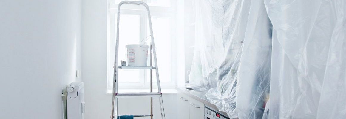 Eine Leiter mit Farbeimer steht in einem Raum, der renoviert wird.